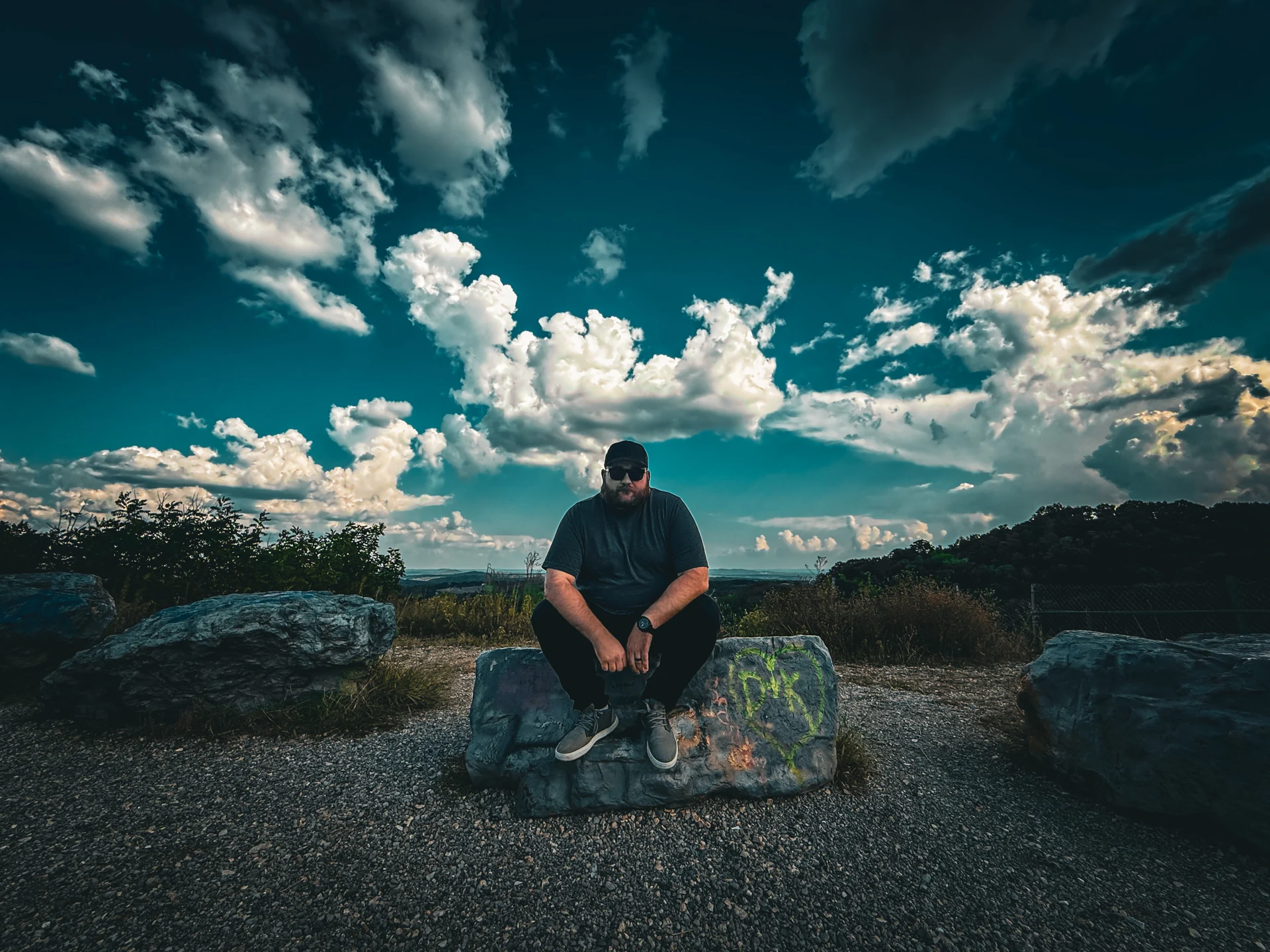 Justice Dover sitting on rocks under a blue sky